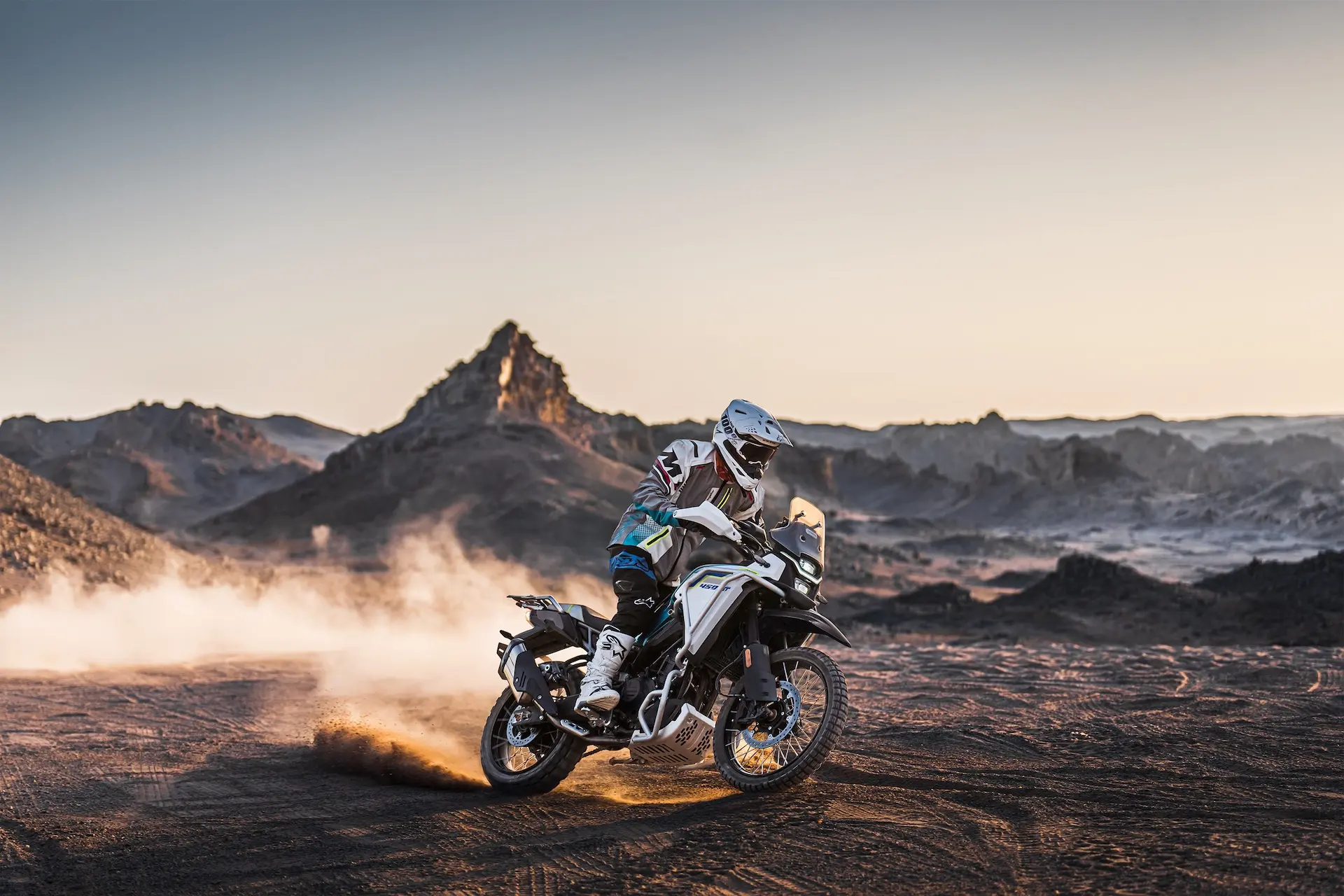 CFMOTO 450MT Zephyr Blue riding through desert terrain at sunset