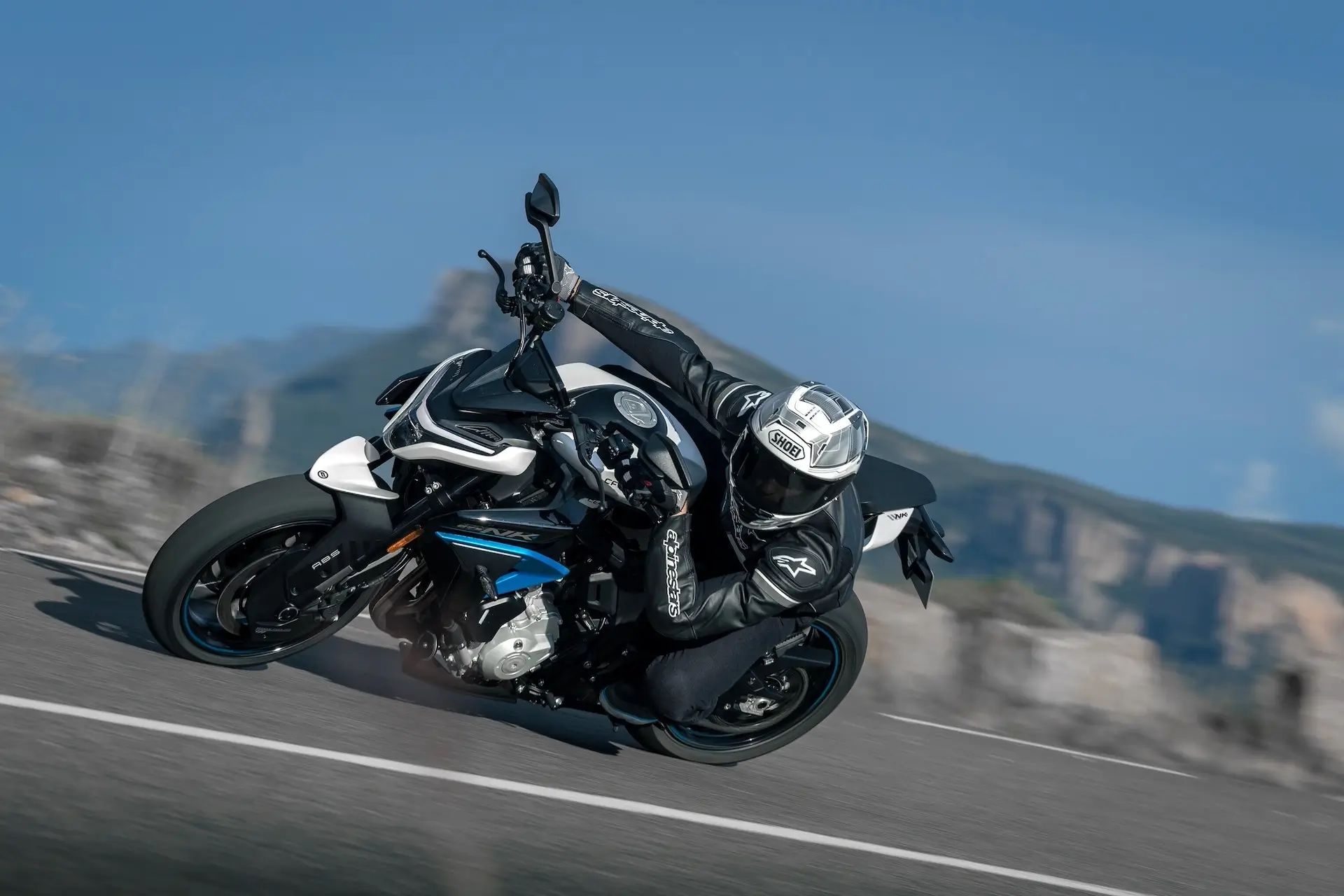 CFMOTO 675NK Glacier White leaning into mountain corner