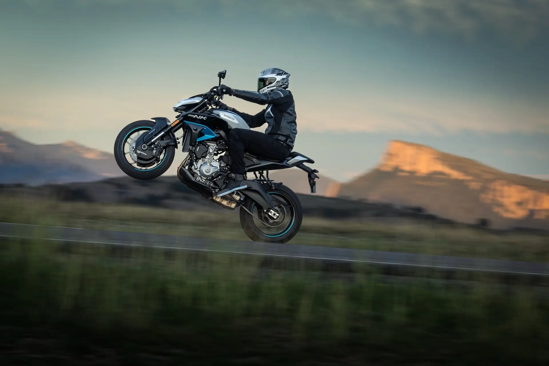 CFMOTO 675NK Glacier White dramatic wheelie at sunset