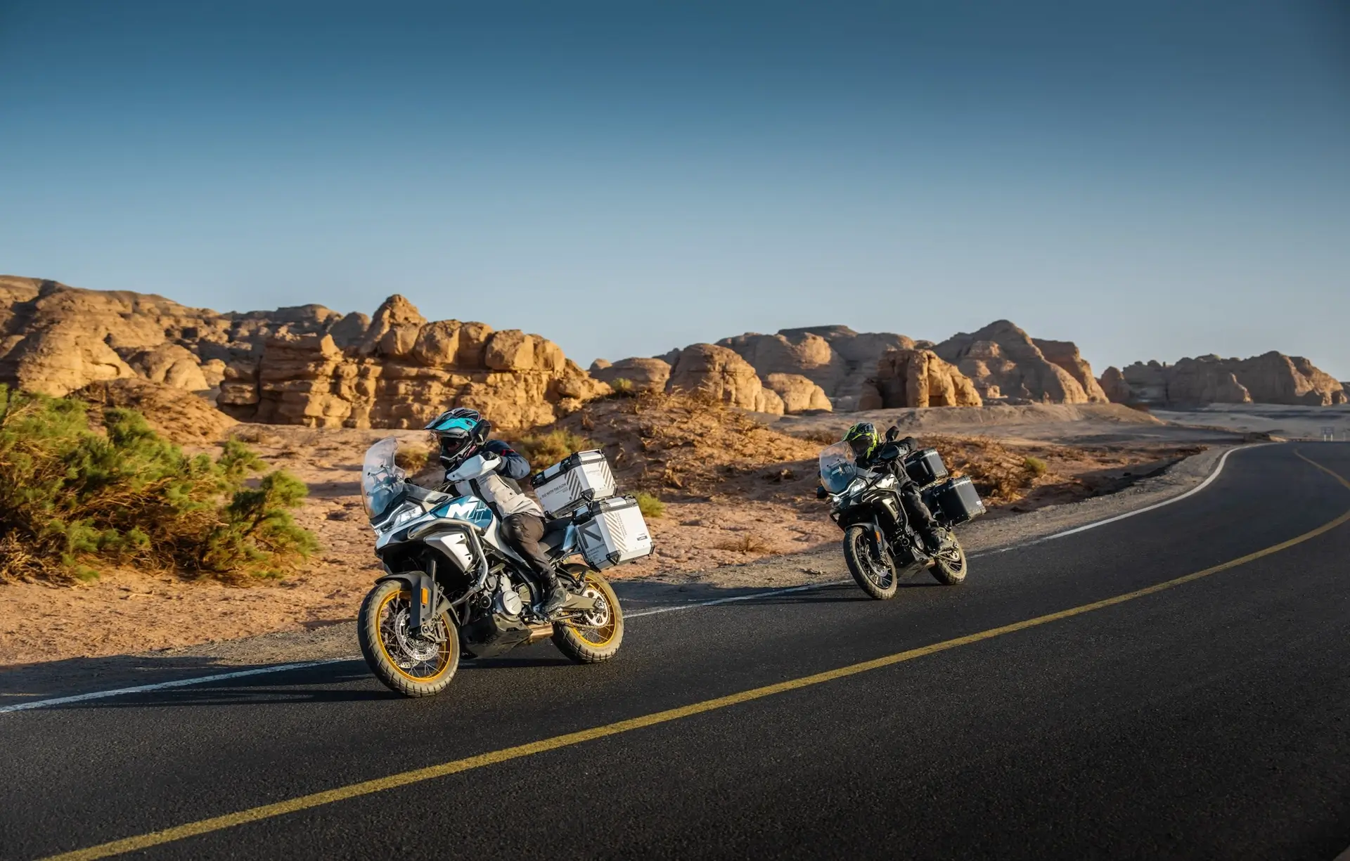 CFMOTO 700MT duo riding through desert canyon road with panniers