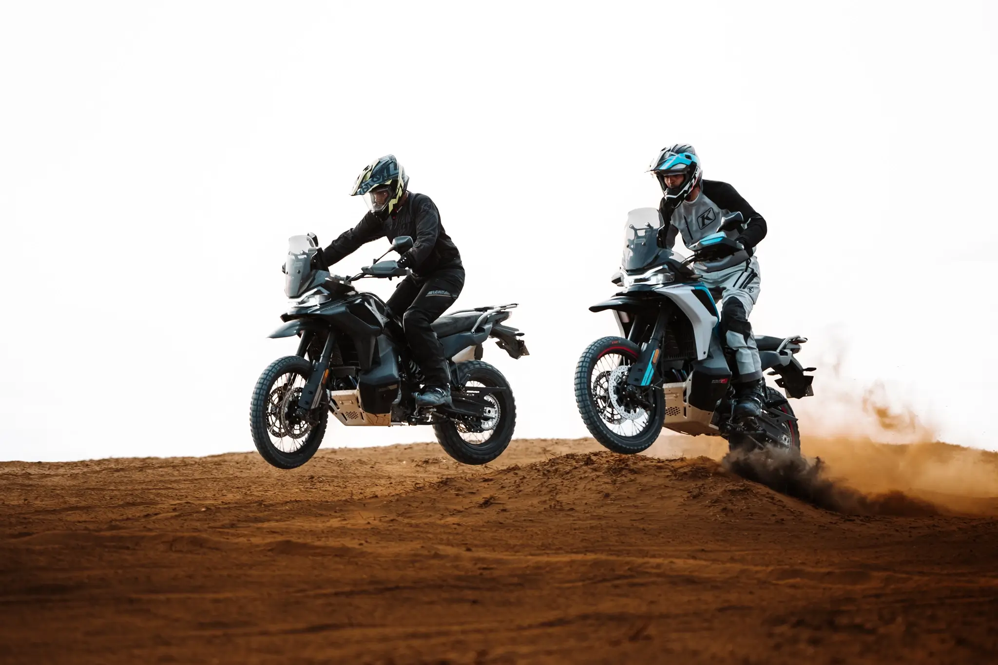 CFMOTO 800MT-X duo jumping off desert dune in both colourways