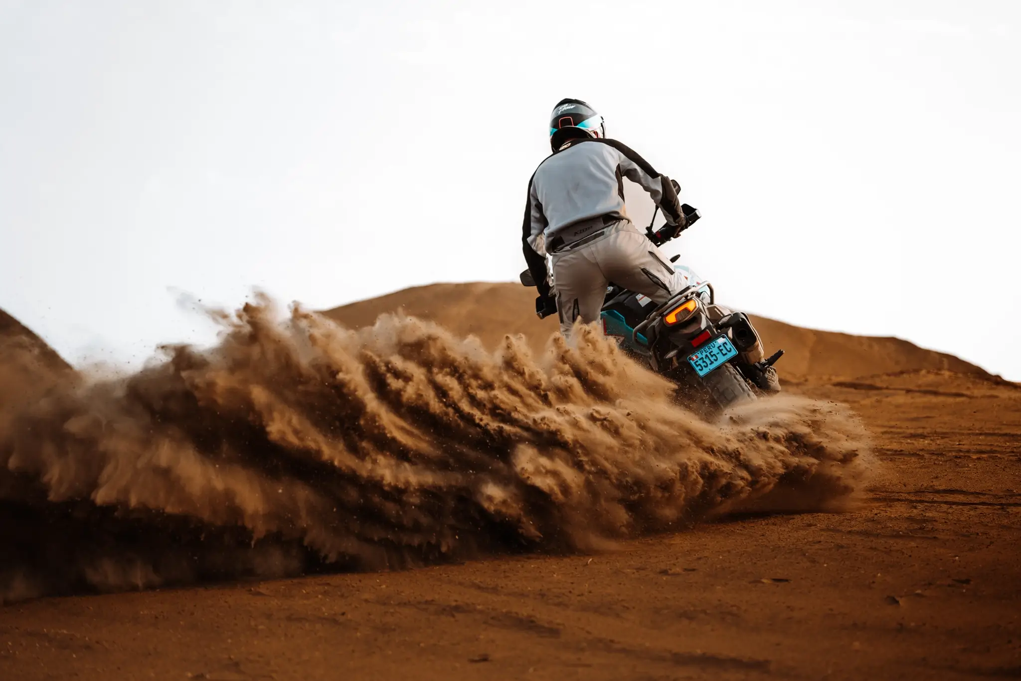 CFMOTO 800MT-X rider kicking up massive sand roost in desert