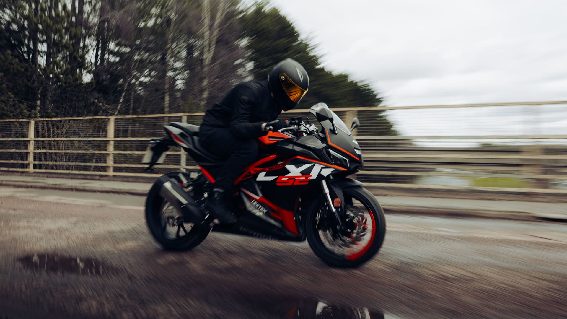 LXR SE 125 rider at speed with motion blur