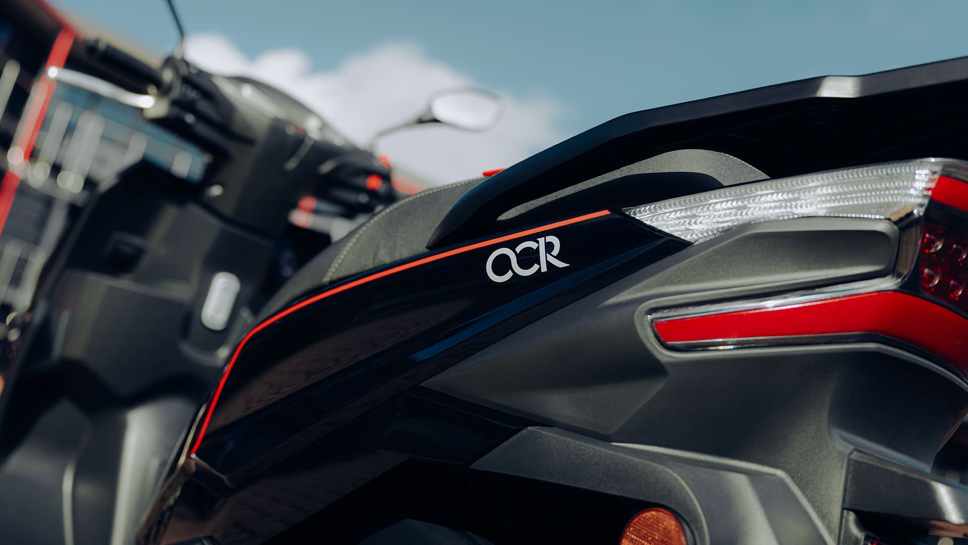 OCR badge and tail light close-up with red pinstripe detail