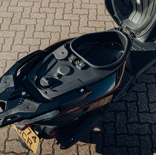 OCR 125 underseat storage compartment open with fuel cap visible