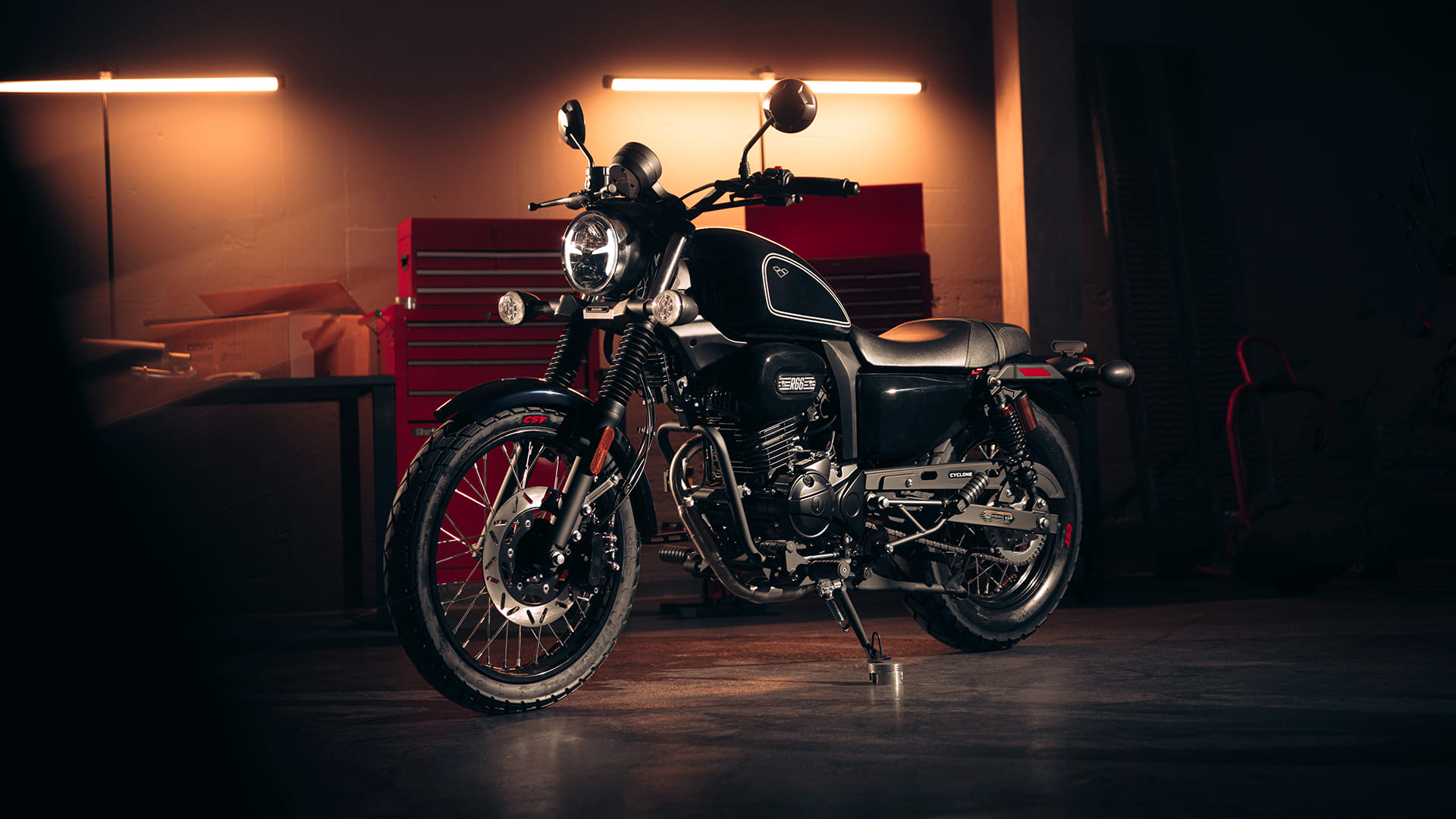 R66 Black front three-quarter in moody garage with warm lighting